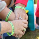 Showing support - hands with beads bracelets stacked in show of support at suicide prevention event